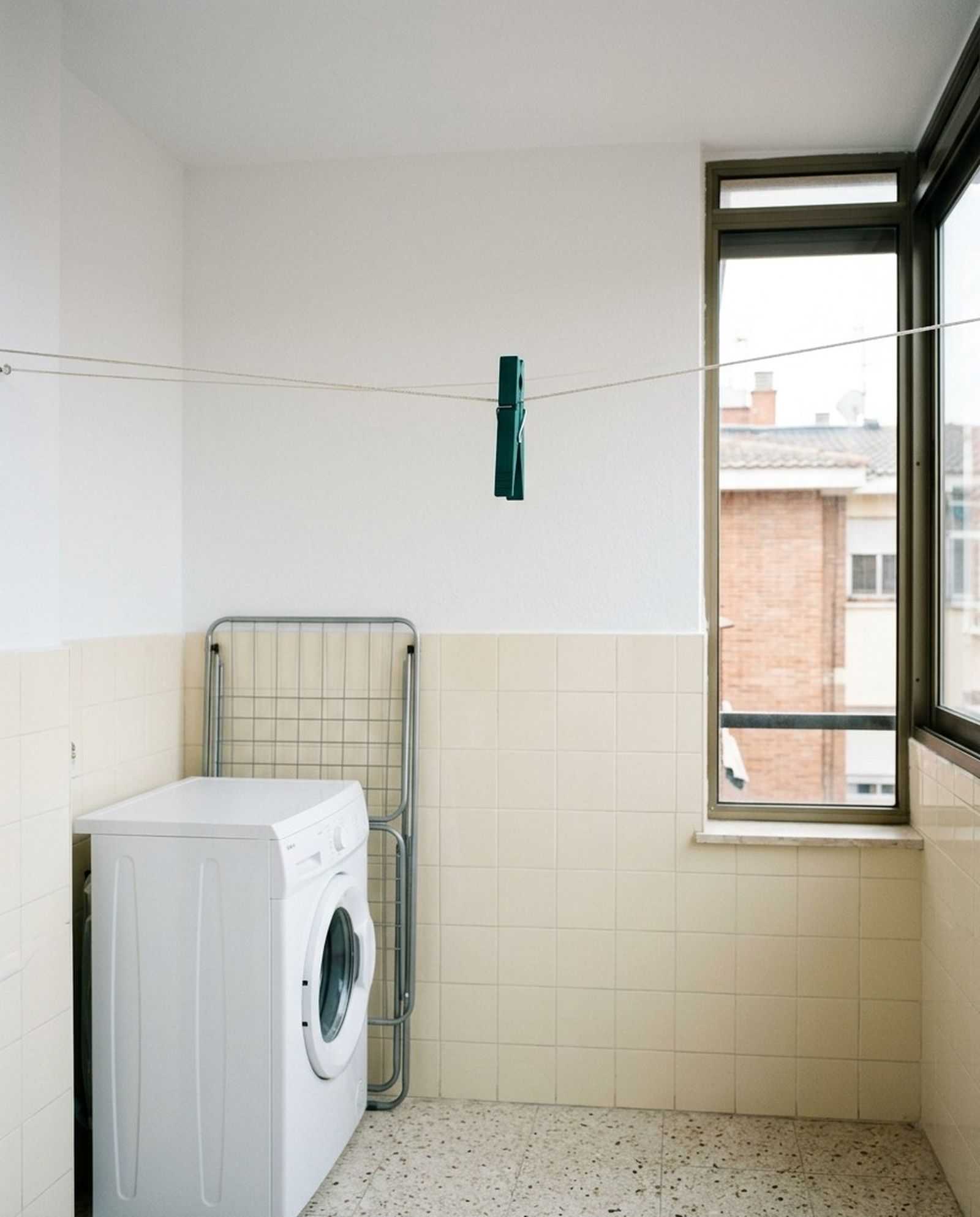 Galería de un piso con la pared alicatada y pintada de nuevo junto a la lavadora