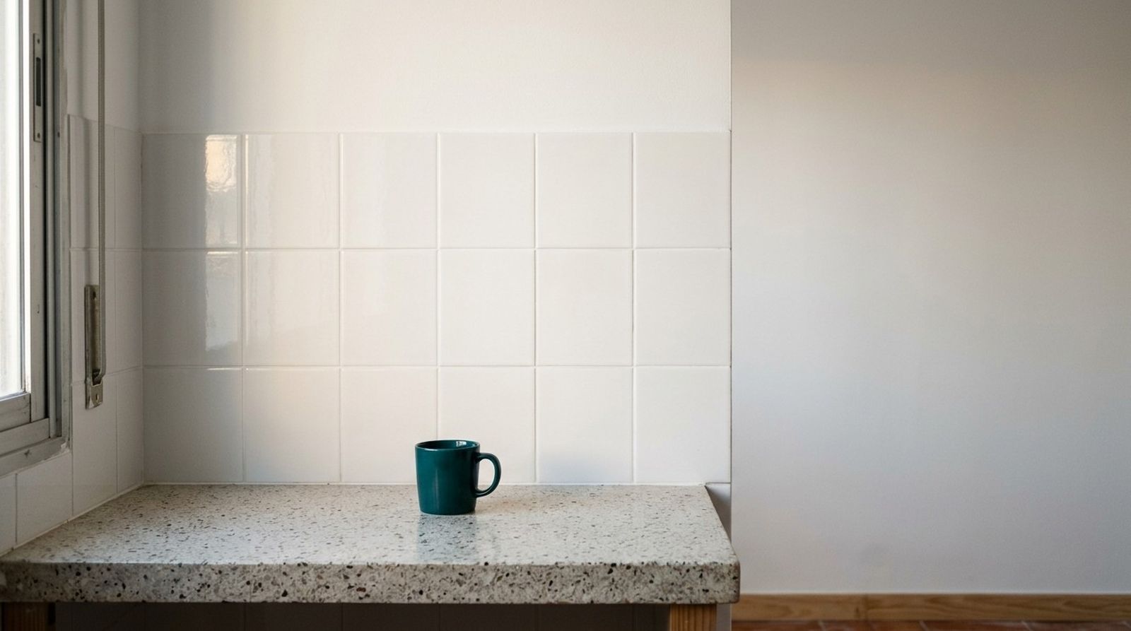 Pared de cocina con azulejos blancos recién colocados y la pared de encima recién pintada
