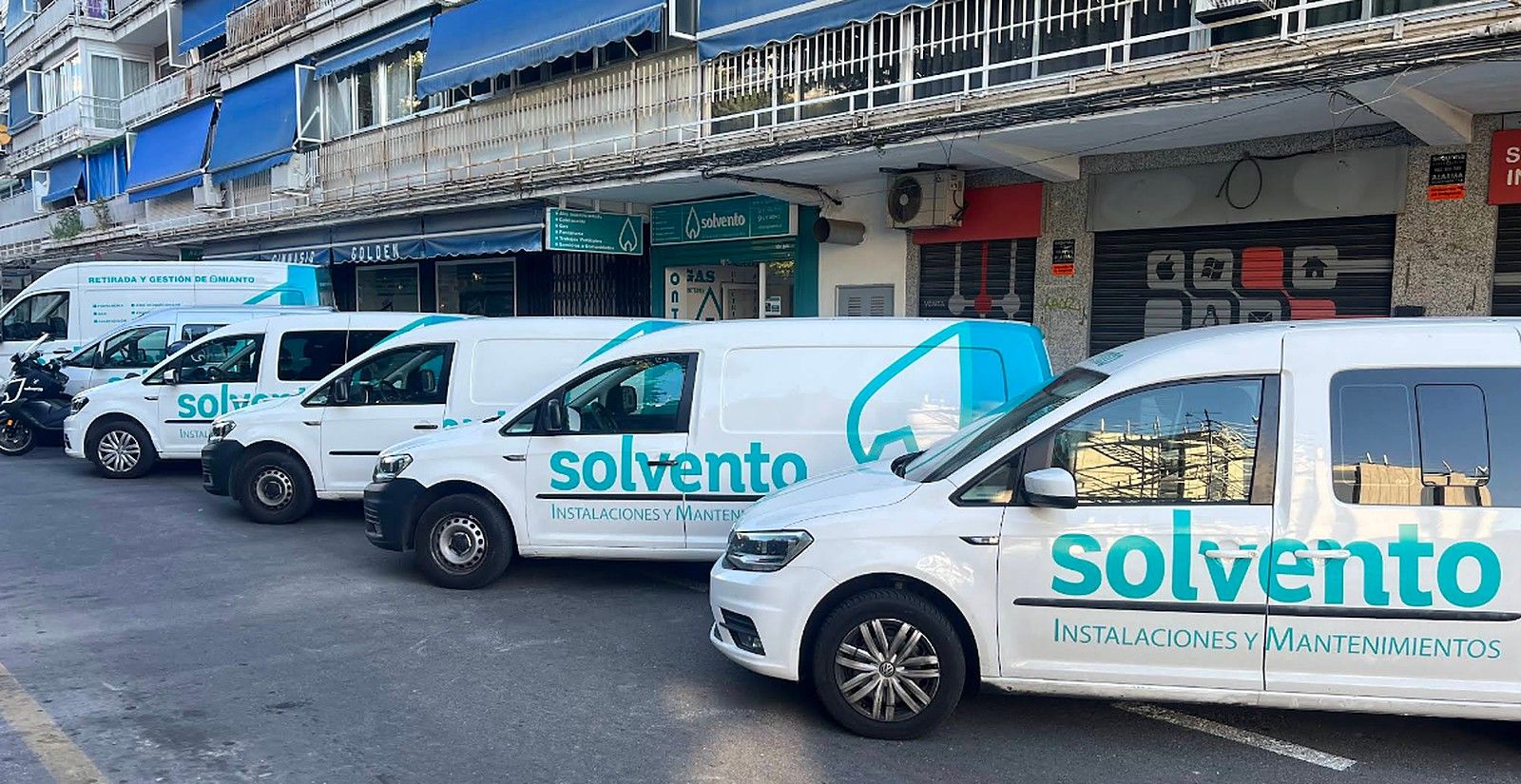 Cinco furgonetas rotuladas de Solvento aparcadas en fila en la calle