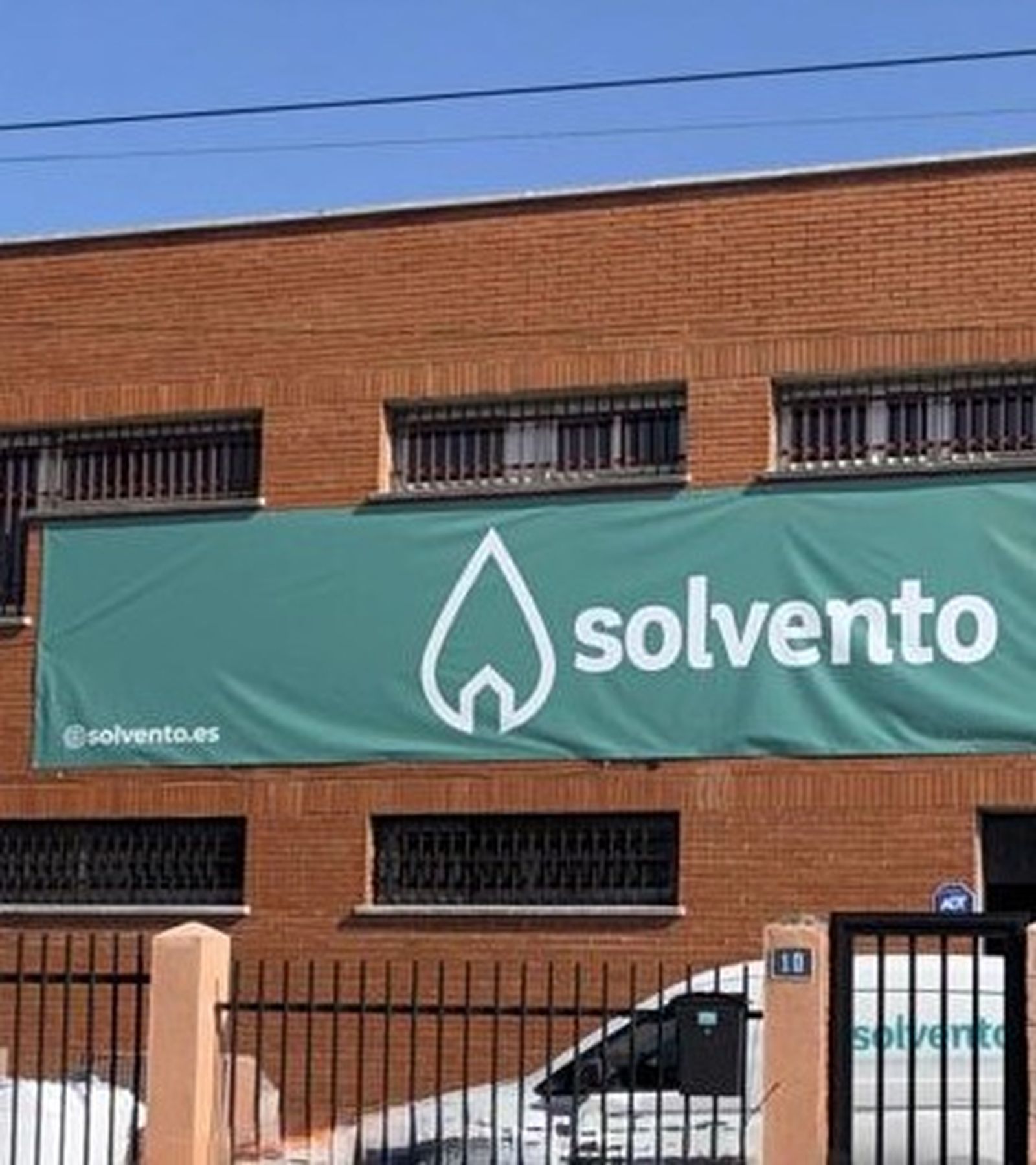 Nave de Solvento en Leganés: fachada de ladrillo con la lona verde del logotipo